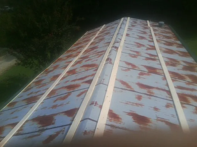 Rusted metal roof panels with new wood purlins before replacement — Storm Damage Roof Repair in Theresa by Roofing Brothers